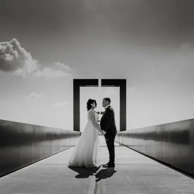 Sur ce pont aux lignes parfaites, leurs chemins se croisent, face à face. Le noir et blanc sublime chaque détail, chaque ombre, chaque trait. La perspective s'étire à l’infini, comme une métaphore de leur union, où deux destins s’alignent.
Leurs regards se répondent, et au milieu de ces lignes pures, c’est la symétrie de deux cœurs qui résonne. Une photo où l’art rencontre l’amour.

#mariagenoiretblanc #photographiedemariage #mariageintemporel #photographedemariage #artetemotion #mariageminimaliste #futuremariés #mariage2025 #mariage2026 #photographedecouple #weddinginspiration #photographique